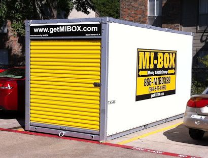 MI-BOX portable storage container shown in a single parking space between two cars -- cars were there when container was delivered